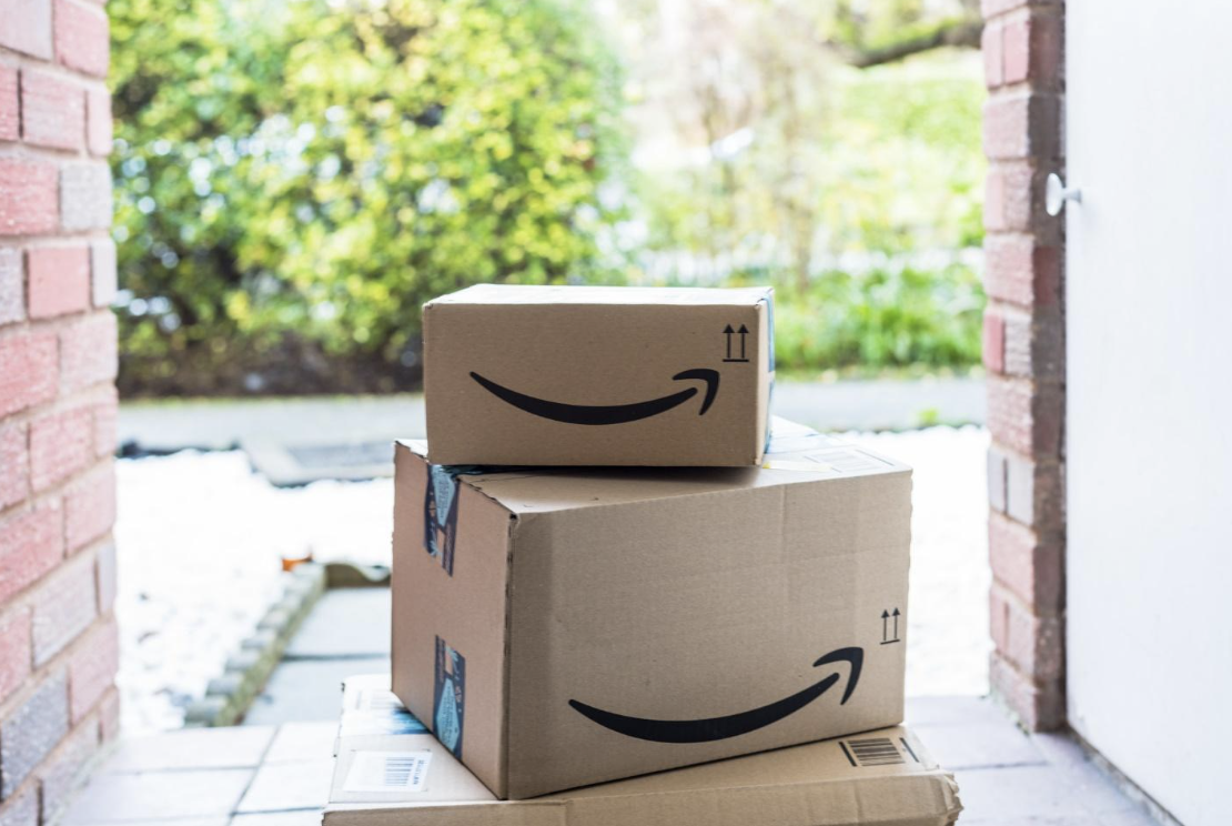 Two Amazon packages delivered and left at the doorstep, symbolizing online shopping and the convenience of home delivery services, with a focus on doorstep package delivery safety.
