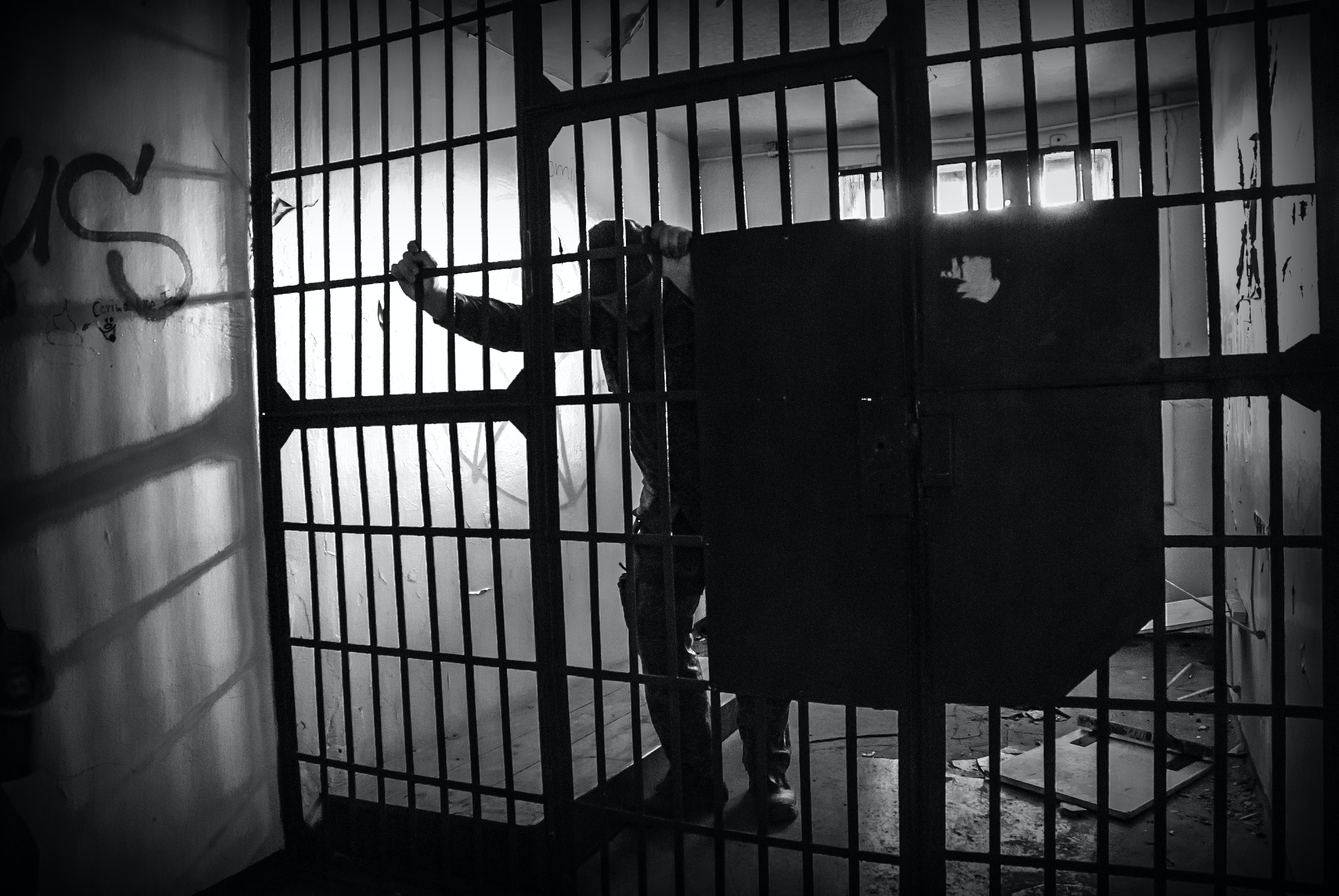 Silhouette of a person behind bars, conveying the stark reality of incarceration, suitable for a blog or article discussing the severe implications of criminal convictions in Arizona.