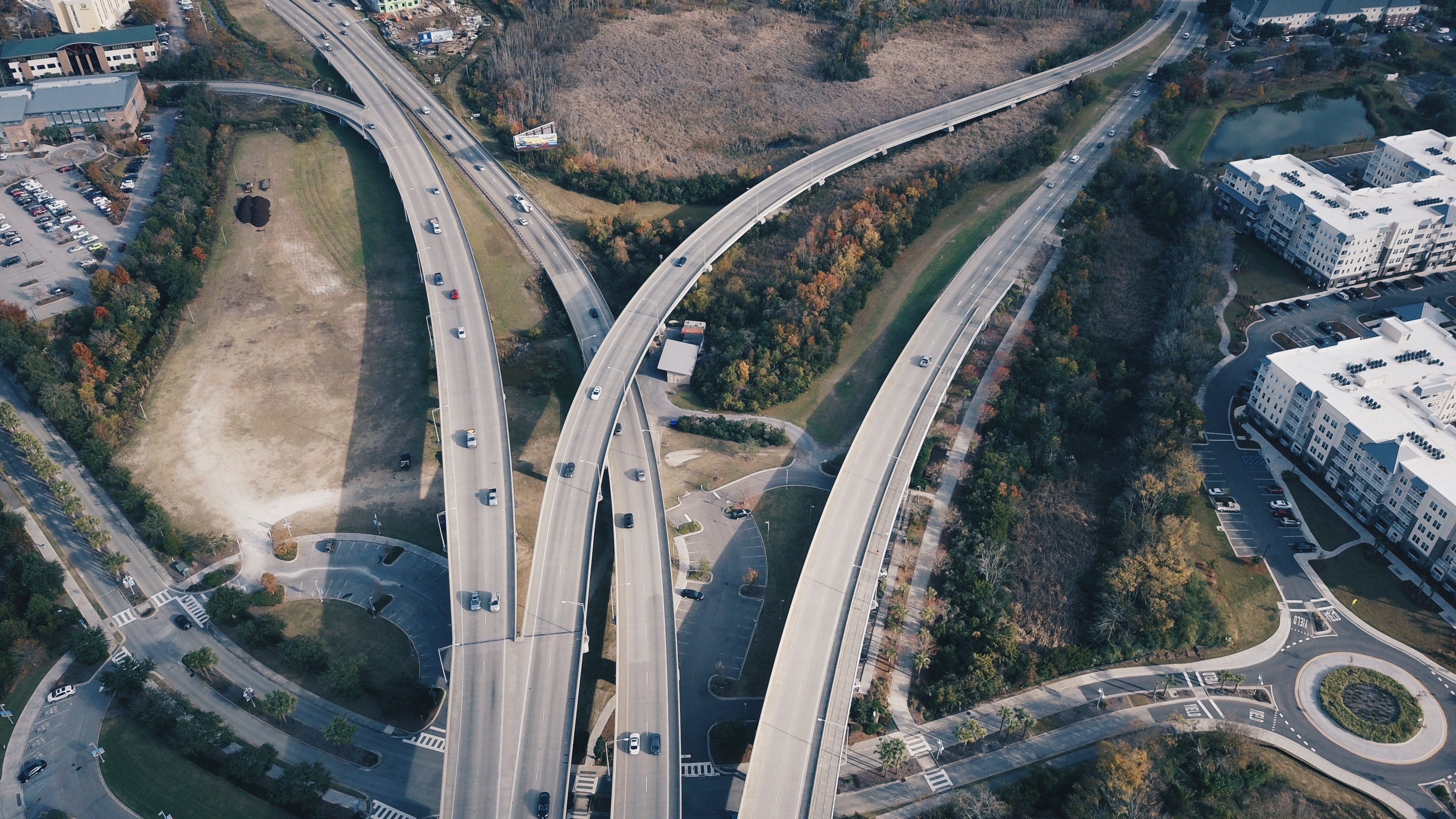 Aerial view of a busy highway interchange with multiple lanes and overpasses, depicting complex roadways that might be navigated during interstate travel, with relevance to laws and regulations surrounding traveling with firearms.
