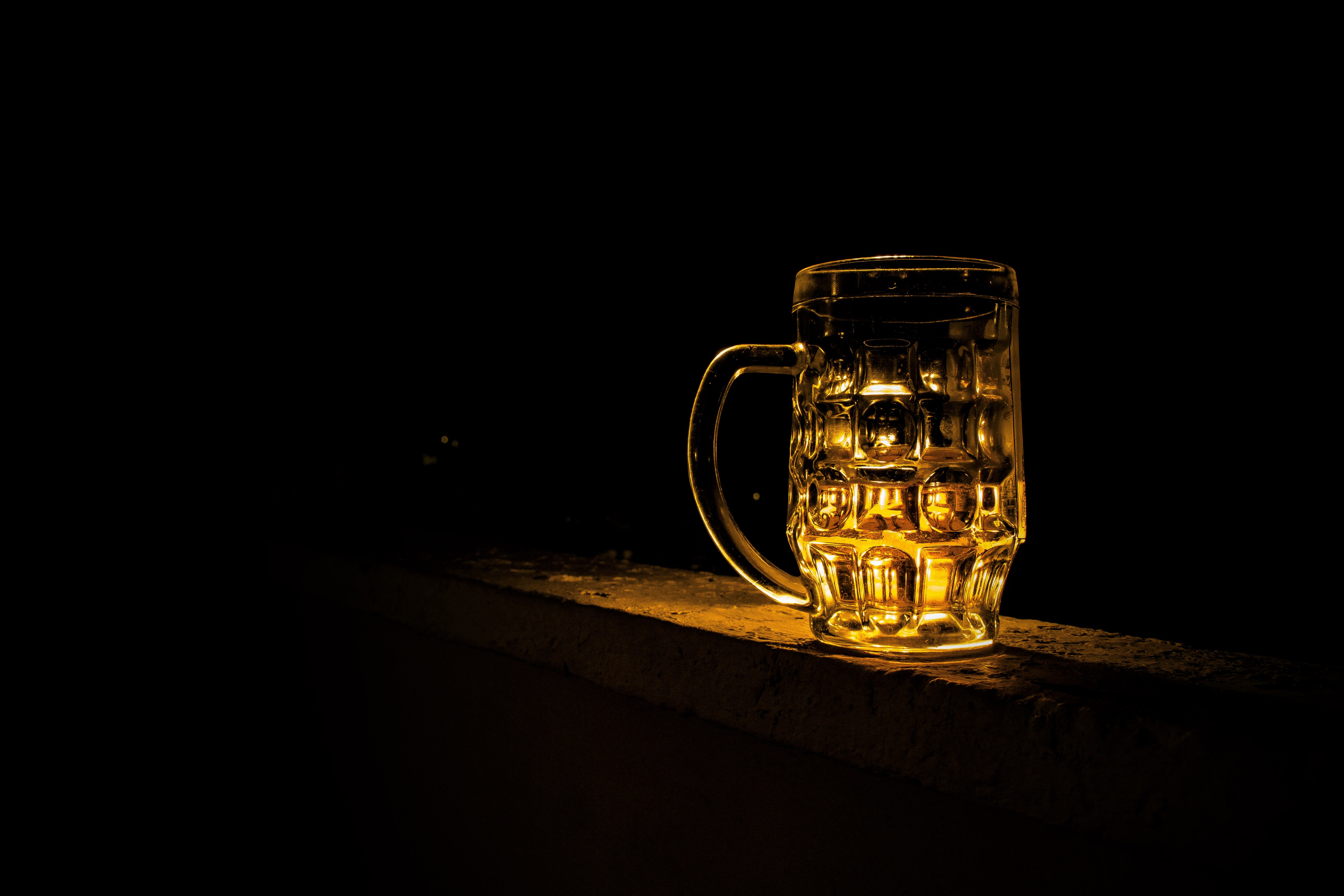 Dimly lit image of a beer mug on a ledge, highlighted by a warm glow, symbolizing alcohol consumption which could be connected to discussions on DUI laws and the severity of such regulations in Arizona.