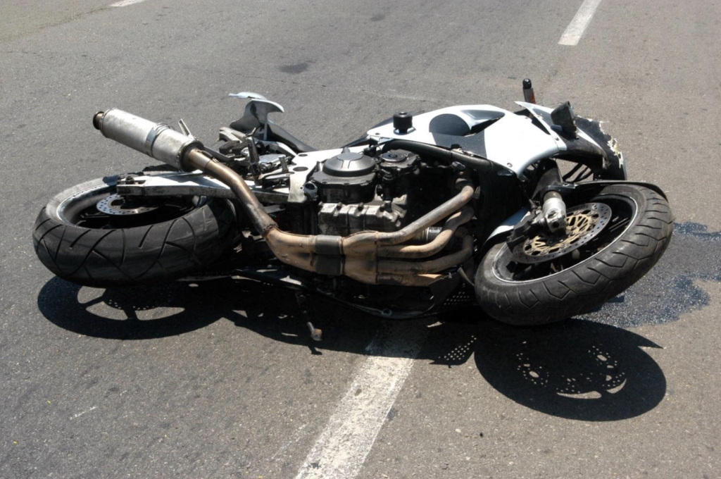 Overturned motorcycle lying on the asphalt with visible damage, representing a motorcycle accident, potentially related to common questions about such incidents in legal contexts.