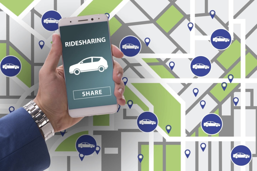 Hand holding a smartphone displaying a ridesharing app interface with a map and car icons in the background, emphasizing the modern context of ridesharing car accidents.